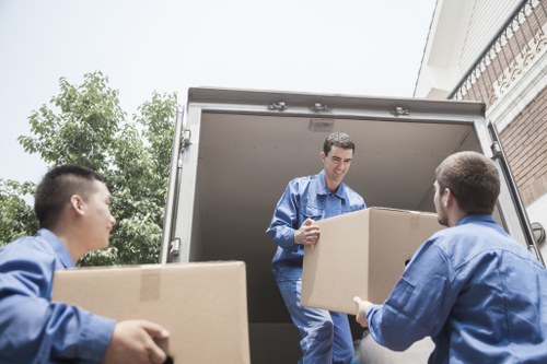 Movers loading household items into a vehicle for a same day relocation